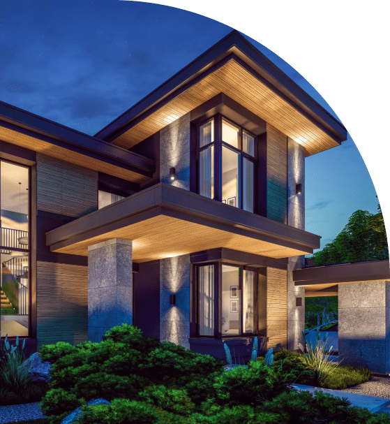 Modern two-story house at dusk with large windows, overhanging roof, and illuminated stone columns. Lush greenery surrounds the front entrance.